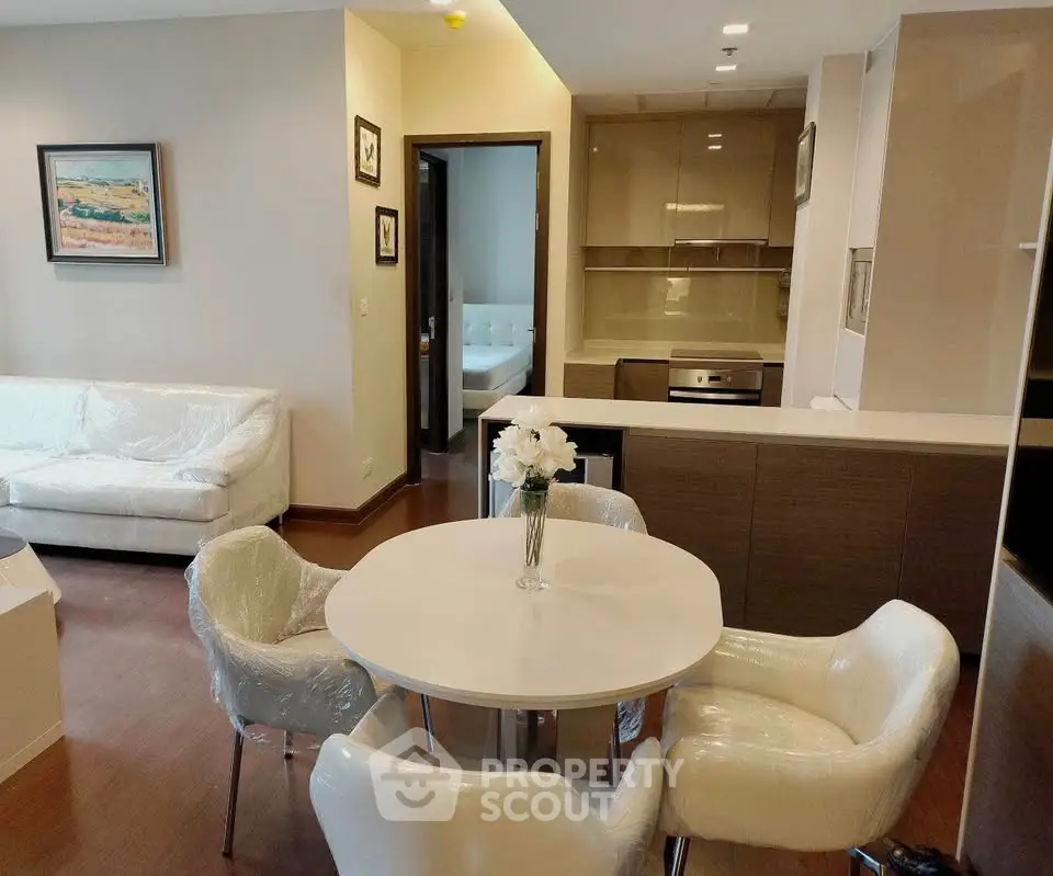Modern living room with open kitchen, featuring elegant furniture and stylish decor in a cozy apartment.