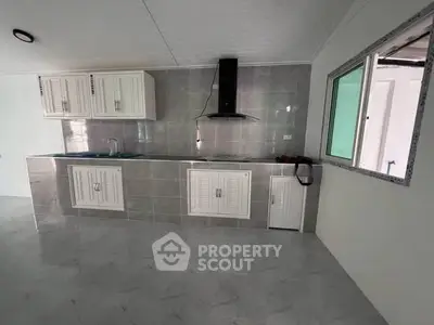 Modern kitchen with sleek cabinetry and tiled backsplash in a contemporary home.
