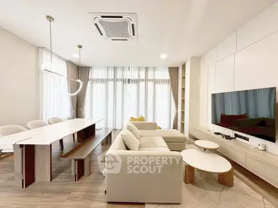 Modern living room with sleek furniture and large windows for natural light.