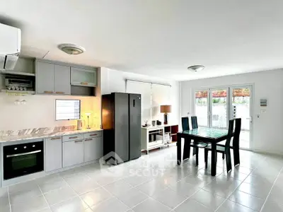 Modern open-plan kitchen and dining area with sleek appliances and natural light.
