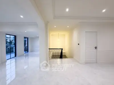 Spacious modern interior with elegant white flooring and stylish lighting, perfect for luxurious living.
