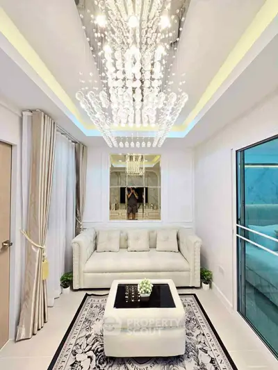 Luxurious living room with elegant chandelier and plush white sofa