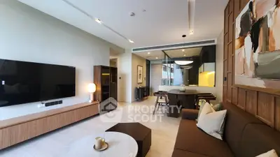 Modern living room with stylish decor and open layout, featuring a large TV and elegant dining area.