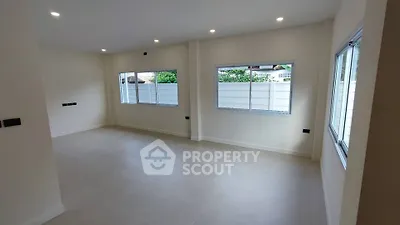 Spacious empty room with large windows and modern lighting