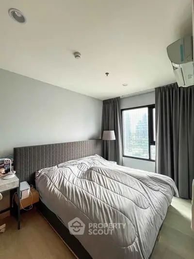 Modern bedroom with city view, featuring a cozy bed and stylish decor.