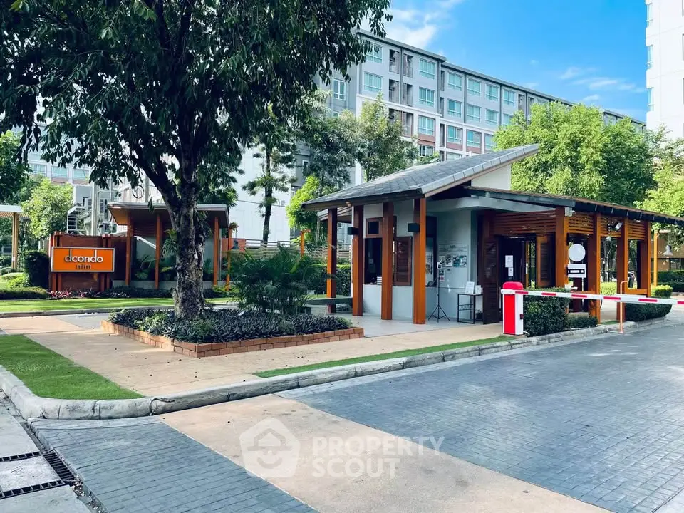 Modern condominium entrance with lush landscaping and contemporary design.