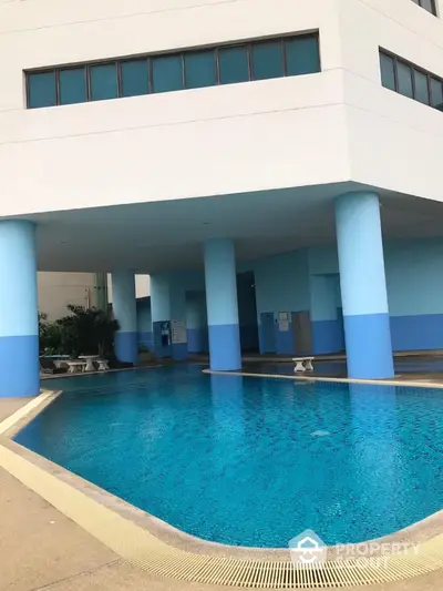 Luxurious residential building with stunning poolside area and modern architecture.