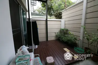 Charming small patio with wooden deck and potted plants, perfect for relaxation.