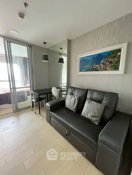 Modern living room with sleek sofa and glass partition in stylish apartment.