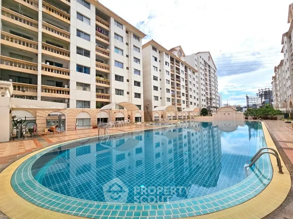 Luxurious apartment complex with a stunning outdoor pool and modern architecture.