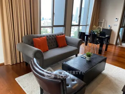 Modern living room with stylish furniture and city view, featuring a cozy sofa and elegant dining area.