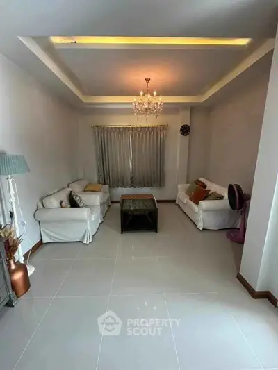 Elegant living room with chandelier and cozy sofas, perfect for relaxation.