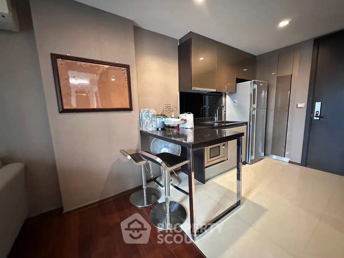 Modern kitchen with sleek cabinetry and breakfast bar in stylish apartment
