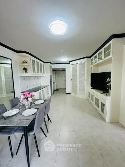 Spacious open-plan living area with modern dining setup and built-in storage cabinets.