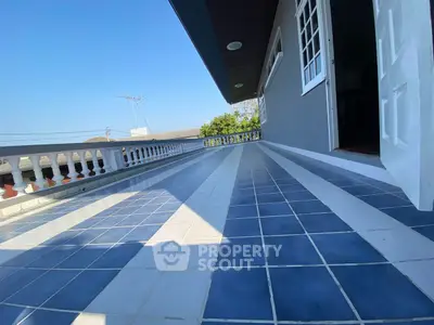 Spacious tiled balcony with open view and elegant railing design.