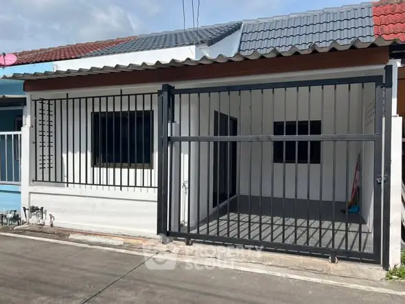 Charming single-story home with gated entrance and tiled roof in a quiet neighborhood.