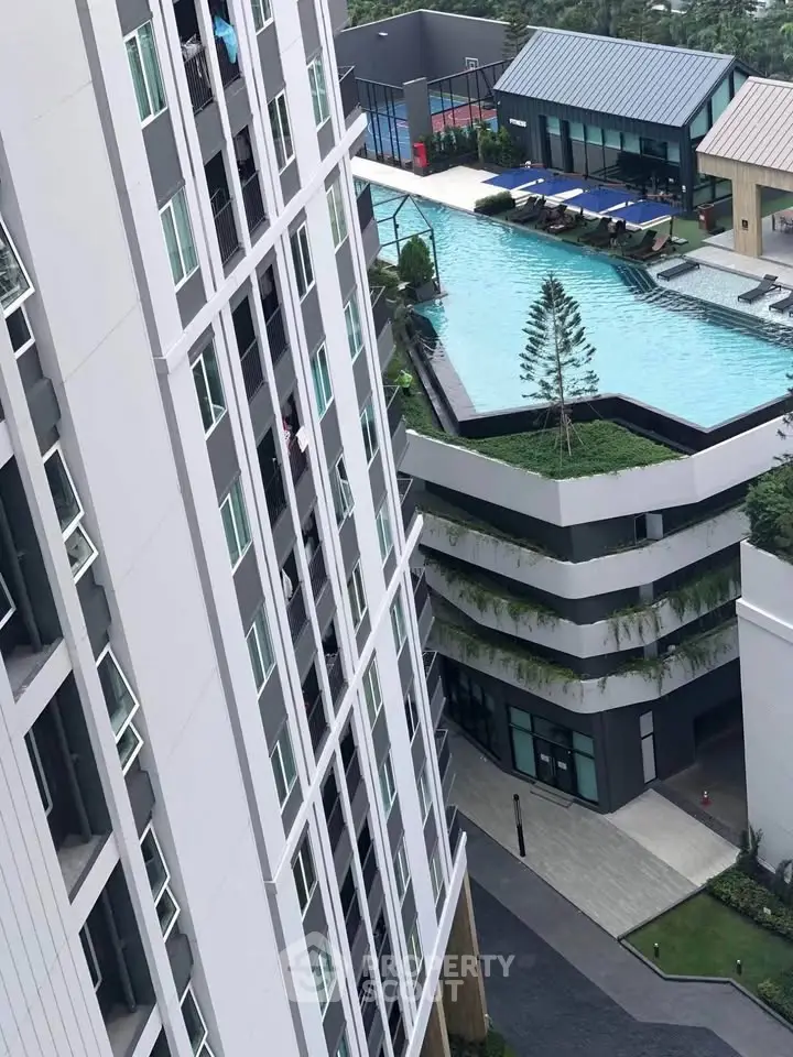 Modern high-rise building with rooftop pool and lush greenery, offering luxurious urban living.