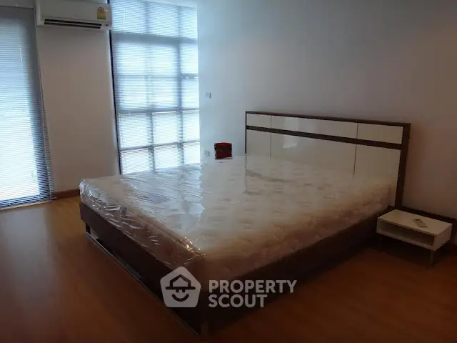 Spacious bedroom with modern design and natural light in a stylish apartment.