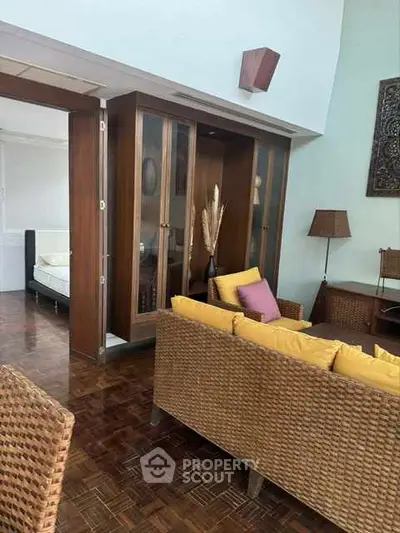 Charming living room with wicker furniture and wooden flooring, featuring a cozy ambiance.