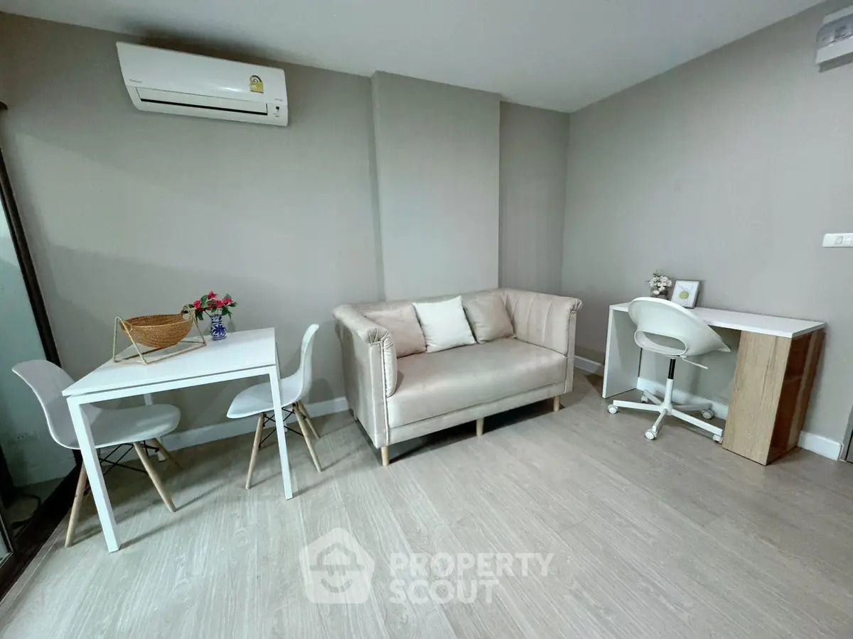 Modern living room with stylish furniture and air conditioning, perfect for a cozy and functional space.