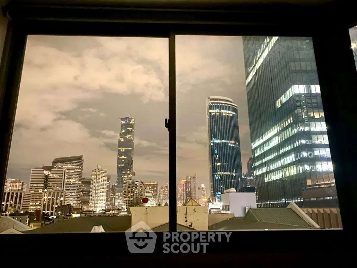 Stunning city skyline view from a window showcasing modern skyscrapers at night.