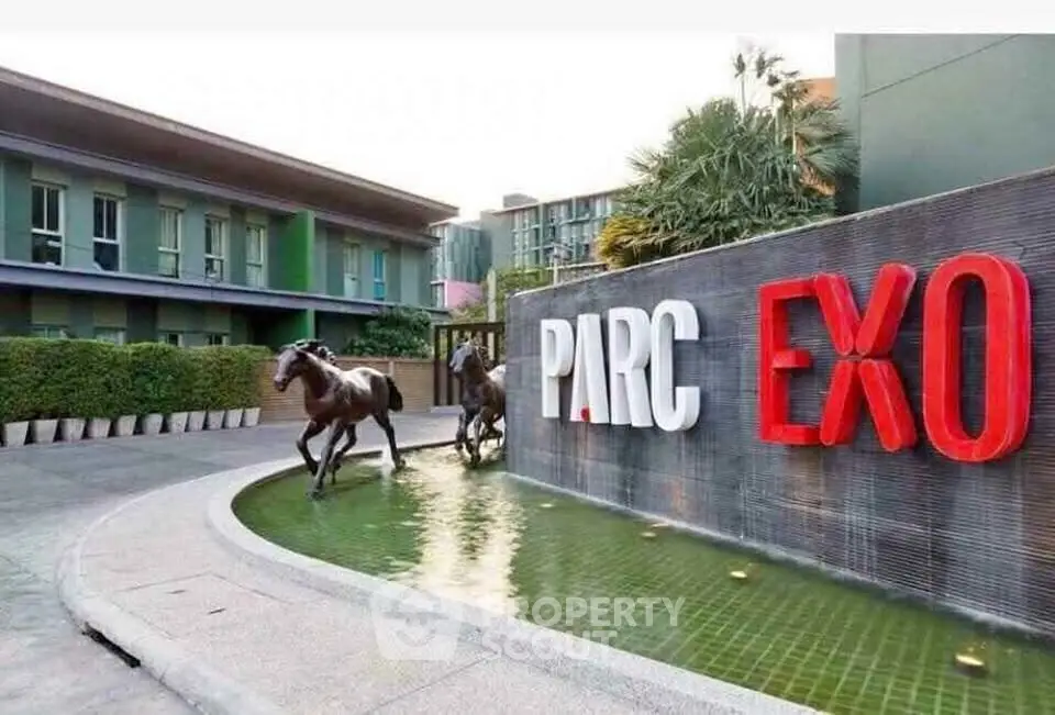 Modern building entrance with water feature and horse sculptures at Parc Exo.