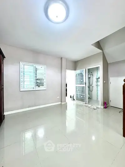 Spacious and bright interior with glossy tiled flooring and modern fixtures, perfect for versatile living arrangements.