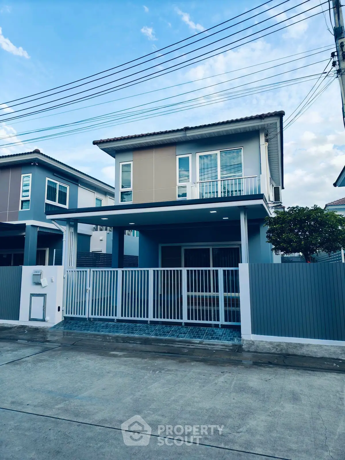 Modern two-story house with gated entrance and contemporary design in a suburban neighborhood.