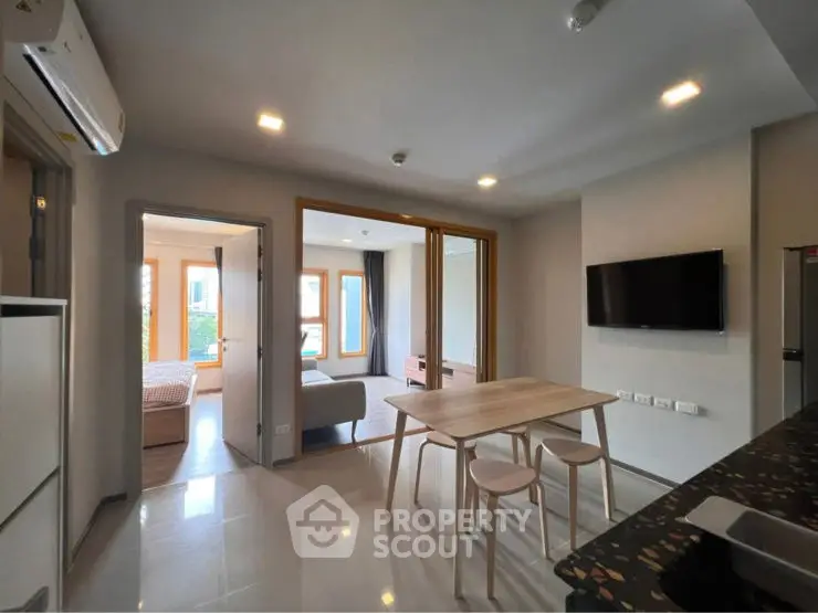 Modern open-plan living space with dining area and wall-mounted TV