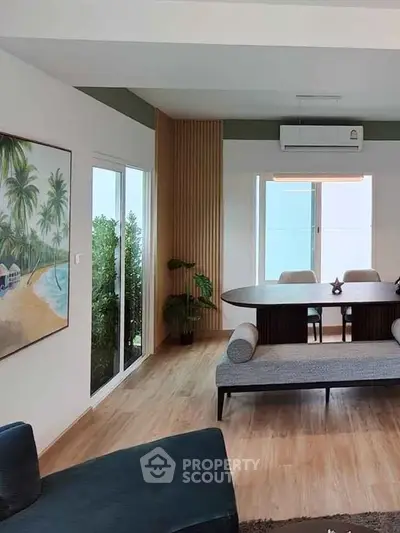 Modern living room with stylish decor and large windows offering natural light.