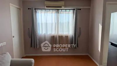 Cozy living room with natural light and air conditioning, perfect for relaxation.