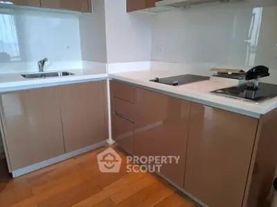 Modern kitchen with sleek cabinetry and built-in appliances, featuring a minimalist design and wooden flooring.