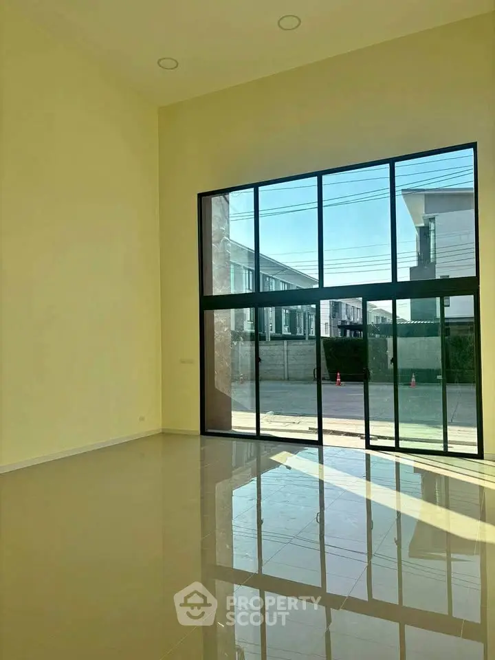 Spacious living room with floor-to-ceiling windows offering abundant natural light and modern design.