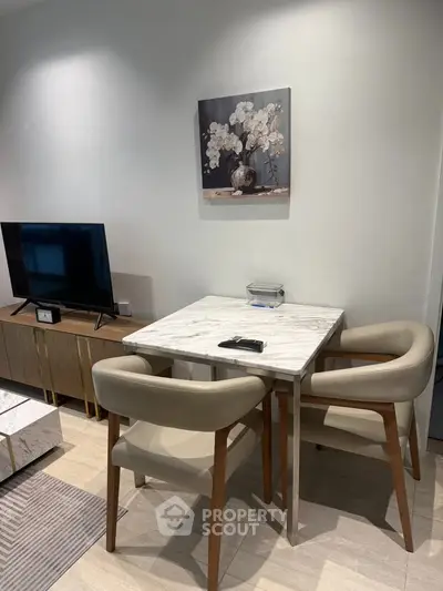 Modern living room with stylish furniture and elegant decor, featuring a marble dining table and sleek TV setup.