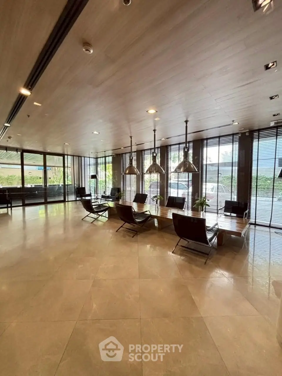 Spacious modern lobby with sleek design and large windows offering natural light and garden views.