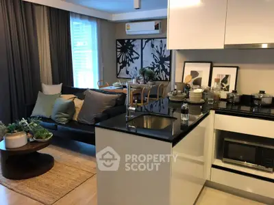 Modern open-layout kitchen and living room with stylish decor and natural light.