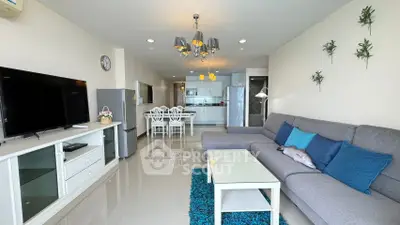 Spacious modern living room with open kitchen, stylish decor, and ample natural light.