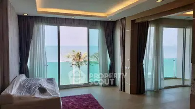 Luxurious living room with stunning ocean view and floor-to-ceiling windows.