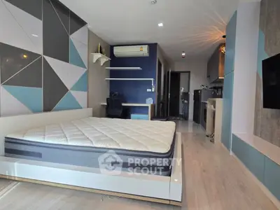 Modern bedroom with geometric wall design and cozy workspace