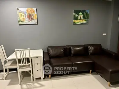 Modern living room with dark leather sofa and stylish wall art