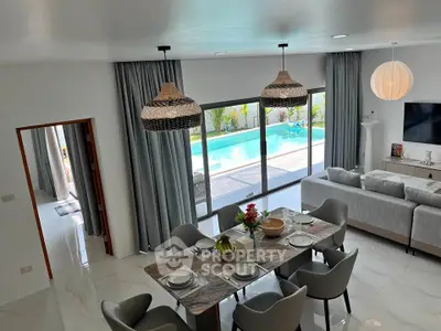Luxurious open-plan living room with pool view, elegant dining area, and modern decor.