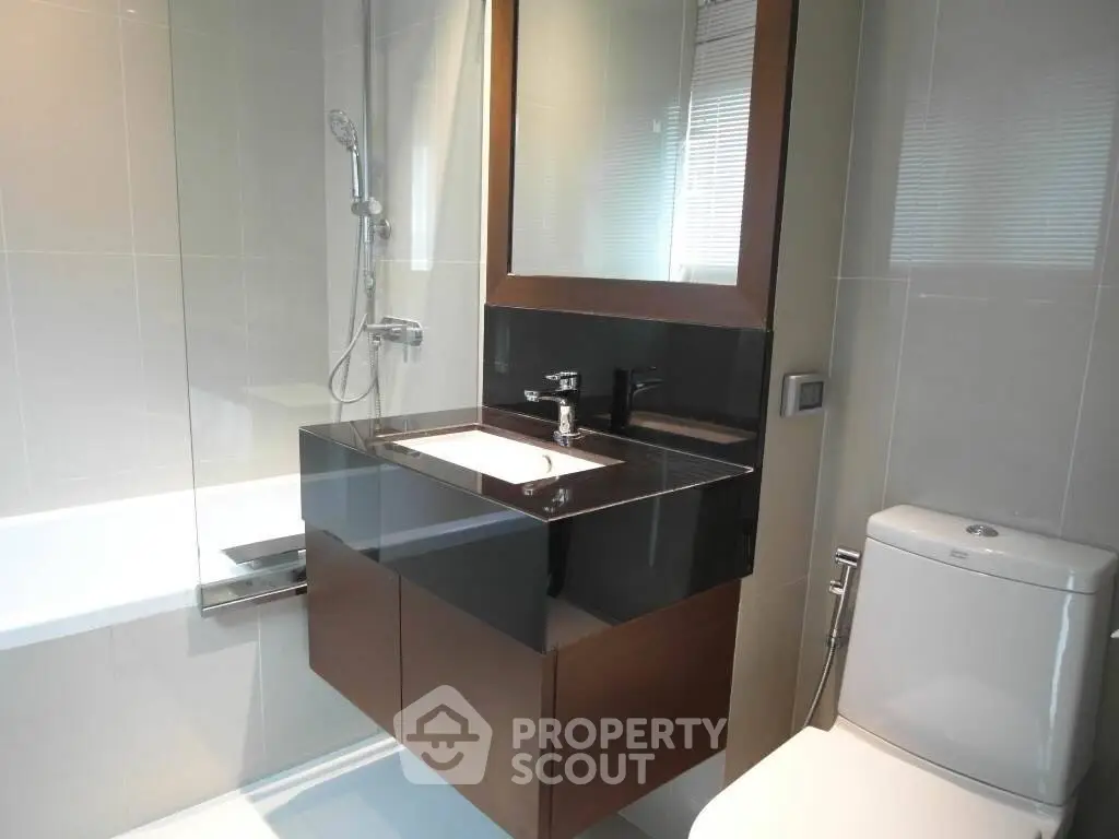 Modern bathroom with sleek fixtures and a bathtub in a contemporary apartment.