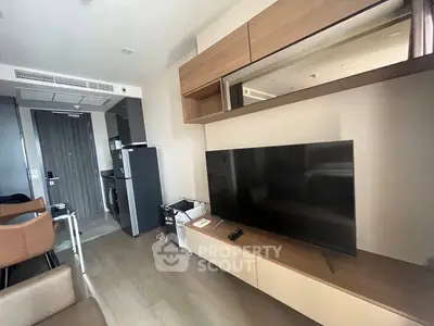 Modern living room with sleek TV and stylish furniture in a contemporary apartment.