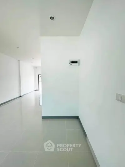 Spacious modern interior with sleek white walls and glossy tiled flooring, perfect for customization.
