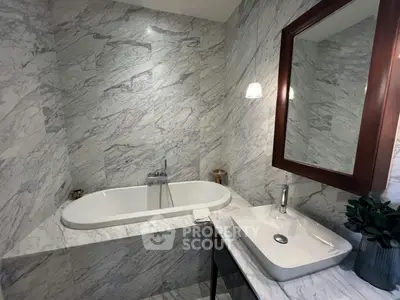 Luxurious marble bathroom with elegant bathtub and modern sink, perfect for relaxation and style.