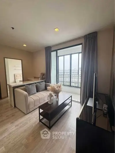Modern living room with balcony view, stylish decor, and natural light.