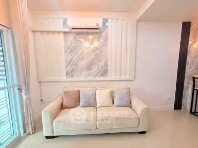 Stylish living room with cozy beige sofa and modern air conditioning unit, perfect for relaxation.
