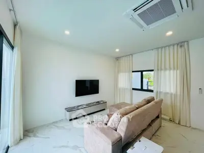 Modern living room with sleek design, featuring a wall-mounted TV, plush sofa, and large windows for natural light.