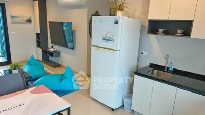 Modern living room with open kitchen, featuring sleek design and vibrant decor.