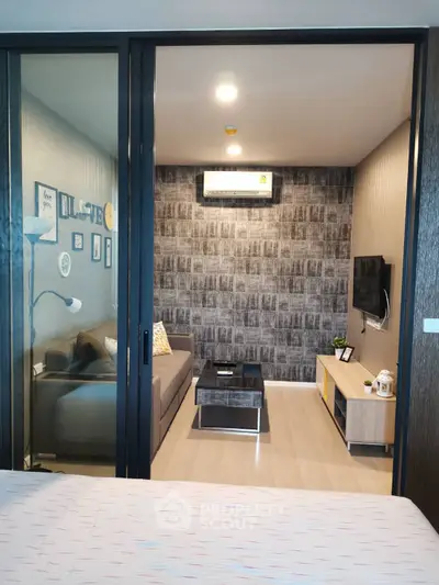 Modern living room with stylish decor and wall-mounted TV in a cozy apartment setting.